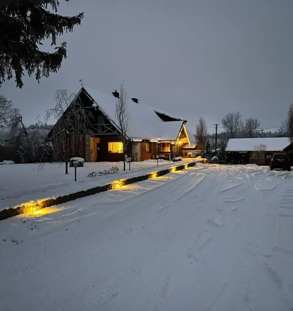 Ferienhaus bei Nacht im Schnee am Rande der Natur