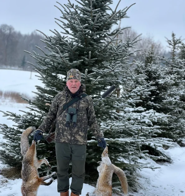 Jagdbeute im Schnee Mann mit Füchsen in der Hand